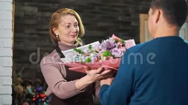 一个人从花店拿一束花。